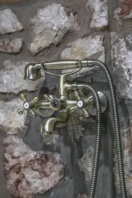 a metal shower head on a stone wall at Petronas Land House 2 in Archangelos