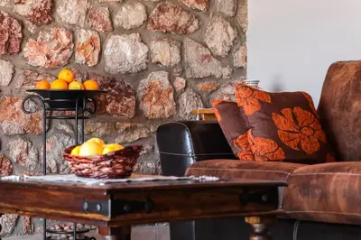 a living room with a couch and a table with a bowl of fruit at Petronas Land House 2 in Archangelos