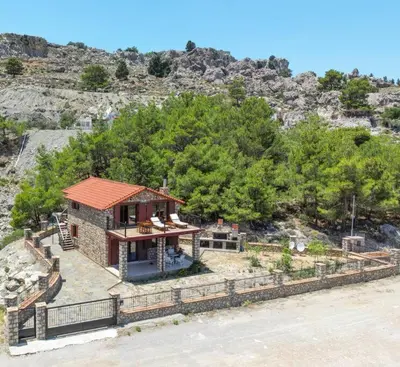 a small house with a red roof on a hill at Petronas Land House 2 in Archangelos