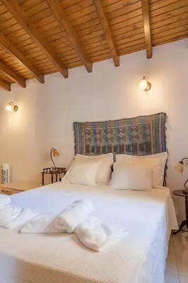 a bedroom with a white bed with towels on it at Kantirimi House - A1 in Symi
