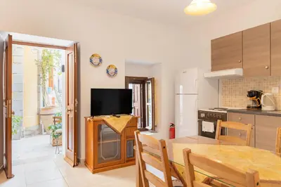 a kitchen and dining room with a table and a television at Kantirimi House - A1 in Symi