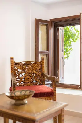 a table with a wooden chair with a bowl on it at Kantirimi House - A1 in Symi