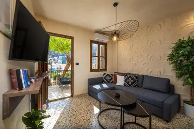 a living room with a blue couch and a table at Townhall Apartment in Symi