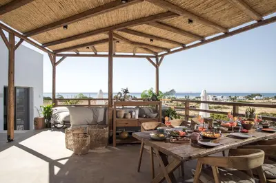 an open patio with a table and a view of the ocean at CasaCarma V, privates XL-Pool, Boho-Design in Lachania
