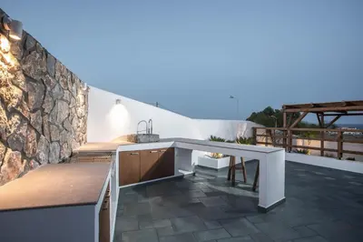 a kitchen with a counter and a stone wall at CasaCarma IV, private XL Pool, Boho-Design in Lachania