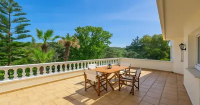 a patio with a table and chairs on a balcony at Villa Small Paradise private pool, jacuzzi, BBQ, complete privacy in Ialyssos
