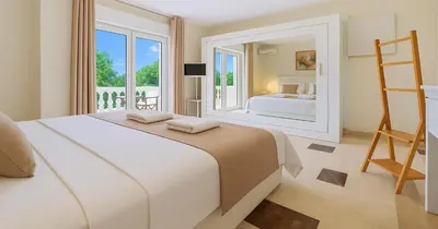 a bedroom with a large white bed and a ladder at Villa Small Paradise private pool, jacuzzi, BBQ, complete privacy in Ialyssos
