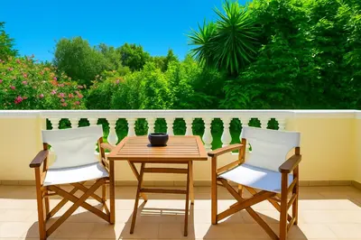 a wooden table and two chairs on a balcony at Villa Small Paradise private pool, jacuzzi, BBQ, complete privacy in Ialyssos