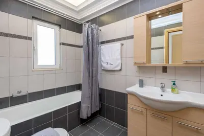 a bathroom with a sink and a shower curtain at Villa Ariadne Lindos in Pefki Rhodes