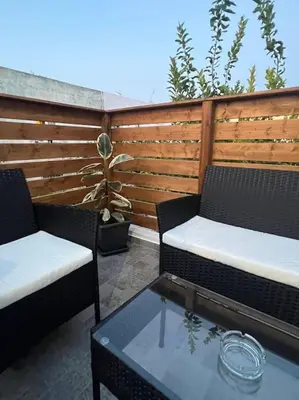a patio with two chairs and a table and a fence at Ikarus Rhodes Center in Rhodes Town