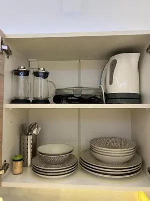 a kitchen shelf with plates and a toaster and dishes at Ikarus Rhodes Center in Rhodes Town