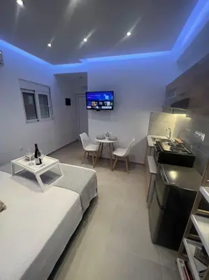 a room with a bed and a table and a tv at Ikarus Rhodes Center in Rhodes Town