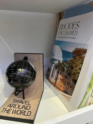 a book and a globe on a shelf next to a book at Ikarus Rhodes Center in Rhodes Town