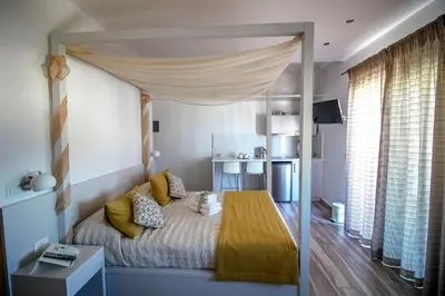 a bedroom with a canopy bed with yellow pillows at Lindos Beauty in Líndos