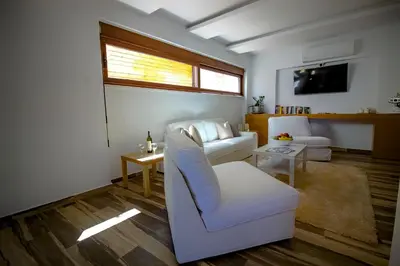 a living room with a white couch and a tv at Lindos Beauty in Líndos