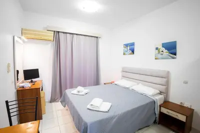 a bedroom with a bed with two towels on it at Johnhara Studios & Apartments in Ialyssos