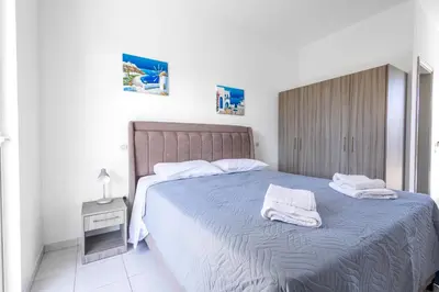 a bedroom with a large bed with towels on it at Johnhara Studios & Apartments in Ialyssos