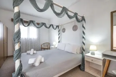 a bedroom with a canopy bed and a desk at Nikolas Apartment in Pefki Rhodes