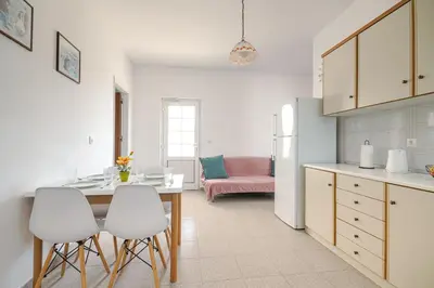 a kitchen with a table and four white chairs at Nikolas Apartment in Pefki Rhodes