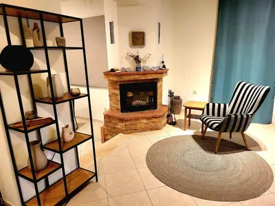 a living room with a fireplace and a chair at Aegean Helios Houses in Gennadi