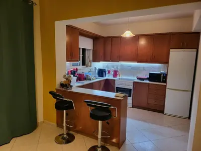 a kitchen with wooden cabinets and a white refrigerator at Aegean Helios Houses in Gennadi