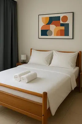 a large white bed with two towels on it at Aegean Helios Houses in Gennadi