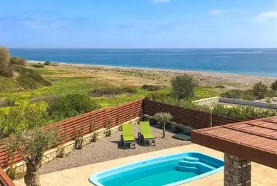 a swimming pool with a view of the beach at Villa Ira in Lachania