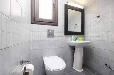 a bathroom with a toilet and a sink and a mirror at Villa Ira in Lachania