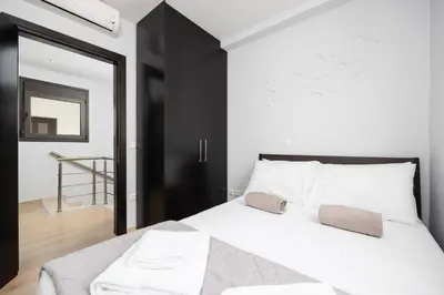 a bedroom with a white bed with a black door at Villa Ira in Lachania