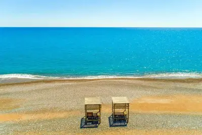 two chairs sitting on a beach near the ocean at Villa Ira in Lachania