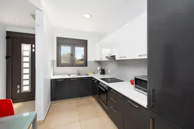 a kitchen with black cabinets and white counter tops at Villa Dias in Lachania