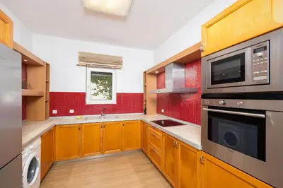 a kitchen with wooden cabinets and a microwave at Villa Pelagos Blue in Yennadhion