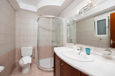a bathroom with a toilet and a sink and a shower at Villa Pelagos Blue in Yennadhion