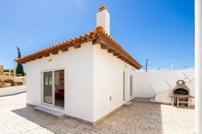 a small white house with a brick courtyard at Villa Pelagos Blue in Yennadhion