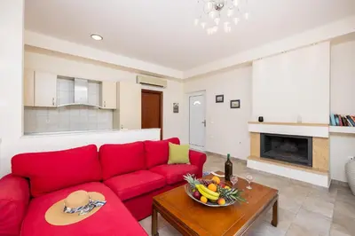 a living room with a red couch and a table at Villa Pelagos Blue in Yennadhion
