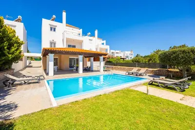a villa with a swimming pool in front of a house at Villa Mediterranean Blue in Yennadhion