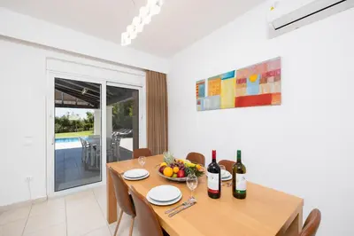 a dining room with a table with wine bottles at Villa Mediterranean Blue in Yennadhion