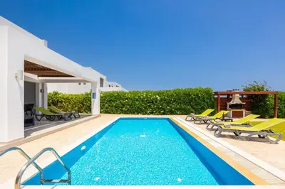 a villa with a swimming pool and patio furniture at Villa Metis in Lachania