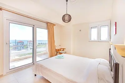 a bedroom with a bed and a large window at Villa Verona Pool in Lachania