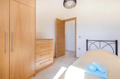 a bedroom with a bed and a wooden cabinet at Villa Verona Pool in Lachania