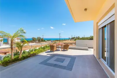 a patio with a table and chairs and the ocean at Villa Verona Pool in Lachania