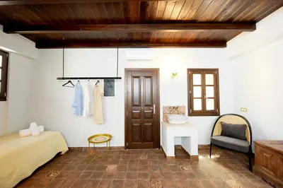 a bedroom with a bed and a table and a chair at Elaia-Fos in Rhodes Town