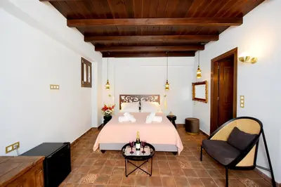 a bedroom with a bed and a chair at Elaia-Fos in Rhodes Town