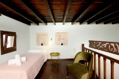 a room with two beds and a chair in it at Elaia-Fos in Rhodes Town