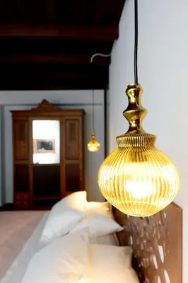 a gold lamp hanging over a bed with pillows at Elaia-Fos in Rhodes Town