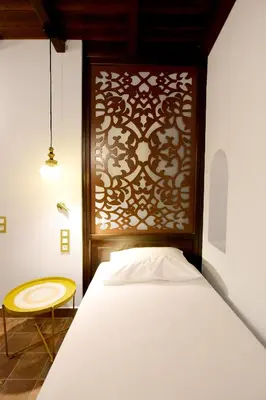 a bedroom with a bed and a wooden headboard at Elaia-Fos in Rhodes Town