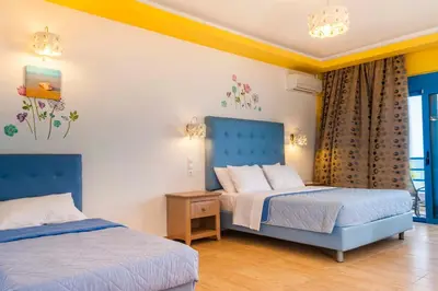 a bedroom with two beds and a window at Haven Beach in Faliraki