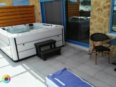 a white bath tub sitting on a patio with a chair at Haven Beach in Faliraki