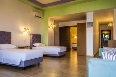 a hotel room with two beds and green walls at Haven Beach in Faliraki