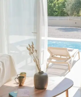 a vase on a table in a living room with a chair at Casa Elia Filerimos in Pastida